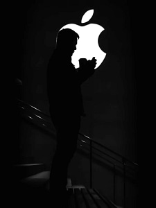 this image is showing half apple logo and a man stands up on the stairs in front of apple logo